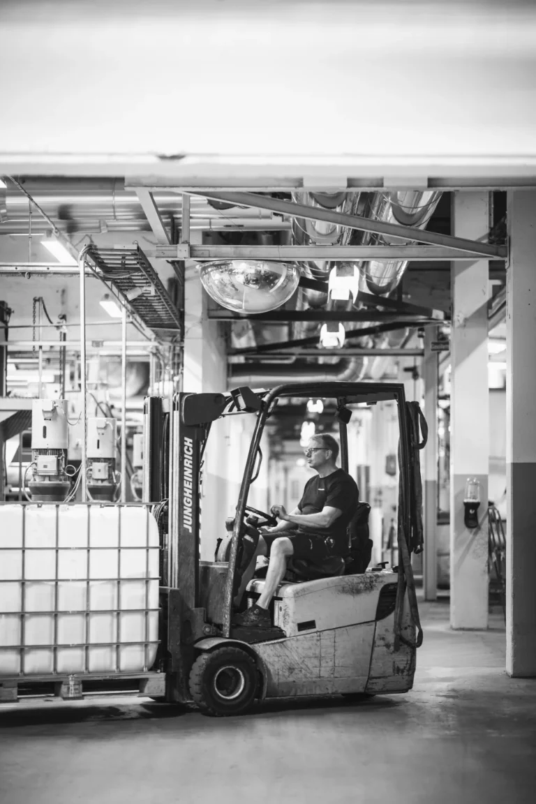 Black and white photo of a truck and a worker in the Almedahls factory.