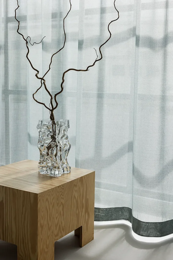 ZEN transparent hanging textile filtering daylight behind a minimal interior setting.