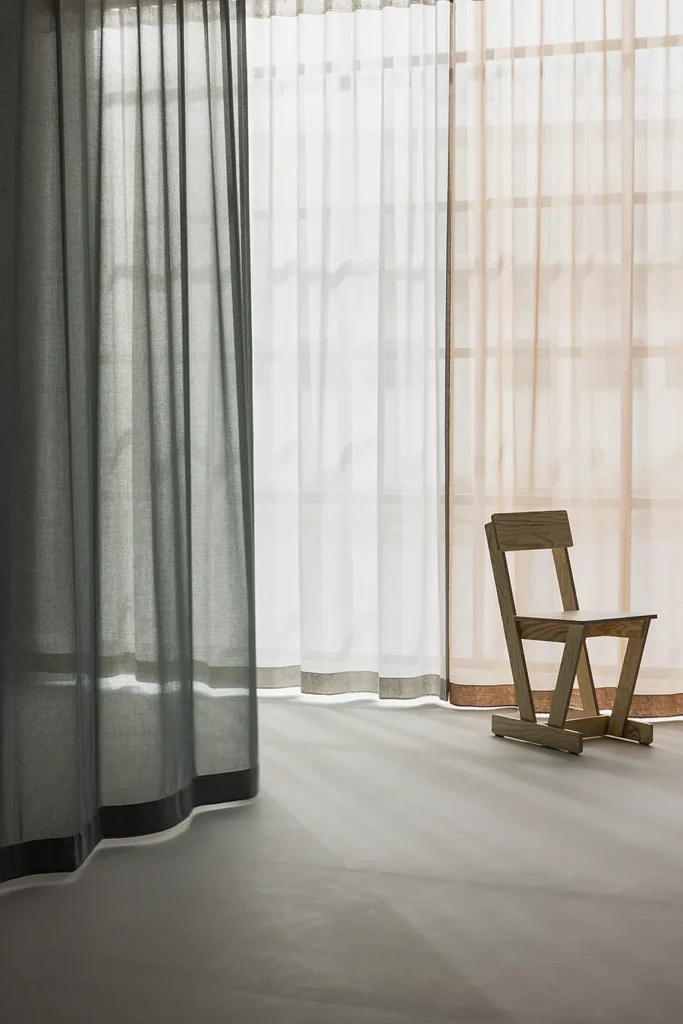ZEN transparent hanging textile filtering daylight behind a minimal interior setting.